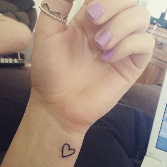 A Person With A Heart Tattoo On Their Wrist