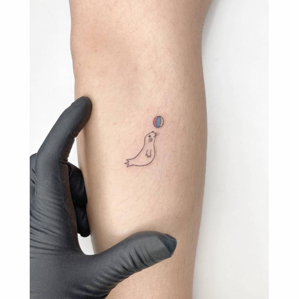 Minimalistic Style Seal Tattoo Located On The Forearm