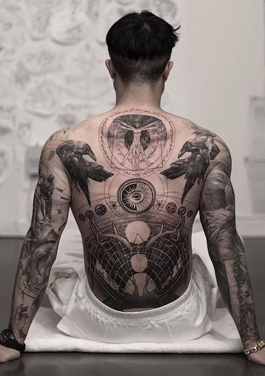 The Back Of A Man With Tattoos On His Body